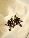 Black folded-ring earrings shown in warm light
