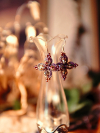 Pink and plum lace earrings hanging from gold hooks.