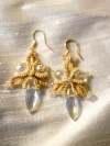 Handmade gold earrings shown on cream fabric