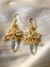 Golden tatted earrings displayed with soft shadows