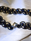 Black choker with shimmering purple beads.