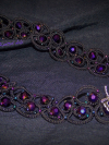 Lace choker displayed on dark fabric.