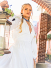 Model in white gown wearing Alaria outdoors