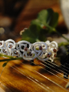 Bracelet draped across a wooden instrument.
