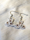 Earrings displayed on soft shimmering cloth.