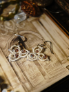 White lace earrings resting on a framed backdrop