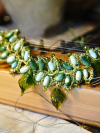 Variegated green tatted necklace resting across wooden instrument