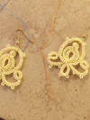 Yellow Holding Bloom tatted lace earrings displayed on tile