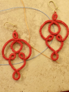Pair of handmade cotton lace earrings displayed on tile.