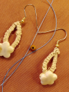 Ocean-inspired earrings with golden shell beads and loops.