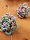 Pair of pastel lace earrings showcasing intricate threadwork.