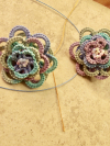 Close-up of handcrafted tatted lace earrings in gentle spring hues.