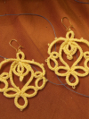 Lotusborne earrings tatted in soft golden thread, full view on fabric