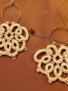 Neutral lace earrings with airy design and soft light.