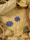 Lace hoop earrings styled on stone with natural props.
