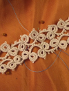 Mistveil Tatted Lace Bracelet on warm fabric backdrop
