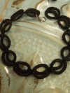 Close-up of Pulsebound bracelet showing looped lacework in black cotton thread.