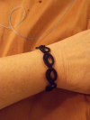 Hand wearing the Pulsebound bracelet with loops visible around the wrist.