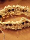 Jute bracelet with wooden beads displayed on warm fabric.