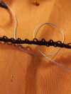Bracelet of dark cotton thread loops, a tribute to shared memory.
