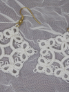 White star lace earrings phographed on vintage-style glass.