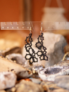 Twilight Tangle - Bold Lace Earrings for Evening Glow Twilight Tangle earrings glowing softly in low light.