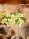 Green lace earrings against rustic background showing depth and color