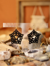 Black lace earrings hang among crystals and seashells.