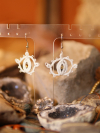 Glimmergaze earrings displayed with geodes and stones