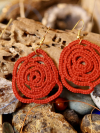 Bold red Sub Rosa earrings displayed with driftwood and gemstones