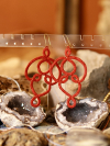 Red tatted lace earrings with looping arcs called Threaded Return.