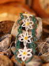 Handmade daisychain bracelet resting on stones
