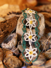Macro view of hand-tatted bracelet inspired by wildflower fields.