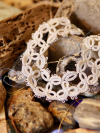 Handmade lace bracelet in white thread with oval patterns.
