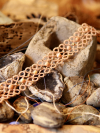 Bracelet made of tatting displayed on backdrop of cement and geodes