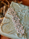Mistveil Tatted Lace Bracelet shown on pressed tin tile