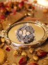Powder-blue lace cameo pin displayed on a vintage silver mirror