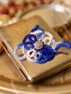 Blue-and-white lace teapot brooch in warm vintage light