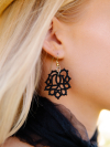 Close-up of black tatted Heirloom Pine earring on ear