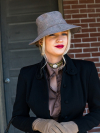 Woman in hat and gloves wearing gold lace choker