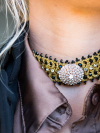 Closeup of gold tatted choker with crystal brooch center