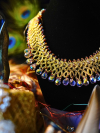 gold lace necklace with iridescent drops on black display bust