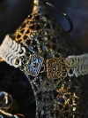 silver-gray tatted choker draped over bronze filigree lantern