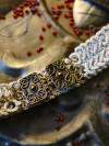 flat-lay of gray chainmail-style tatted choker on metal surface