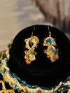 Close-up of Sandy Treasures earrings with ocean blue beads, pearls, and shells.