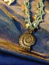 Coastal-inspired necklace with aqua seashell beads and silver trimmed lacework.