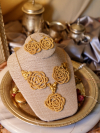 Hand-tatted gold rose earrings and necklace with brass accents on display bust