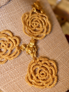 Close-up of gold lace roses linked with vintage brass connectors