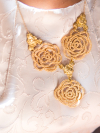 Golden lace necklace worn with vintage-style cream dress