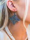 Close-up of tatted black lace earrings on model